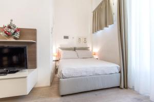 Habitación blanca con cama y TV en Santa Croce Studio, en Florencia