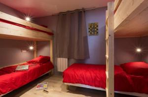 2 camas en una habitación con sábanas rojas en Belle Plagne Prestige, en Belle Plagne