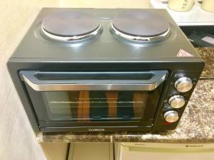 a stove top oven sitting on top of a counter at London Luxury Ensuite Apartment in Ilford