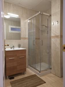 La salle de bains est pourvue d'une douche en verre et d'un lavabo. dans l'établissement apartamentos TAIDÍA, à Playa del Ingles