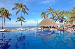 una piscina con palmeras y el océano en Marival Emotions Resort All Inclusive - Future Mercure en Nuevo Vallarta 