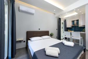a bedroom with a large white bed and a kitchen at Dorotea Luxury Rooms in Ipsos