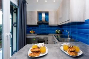 una cocina con 2 platos de bollería y zumo de naranja en Dorotea Luxury Rooms en Ypsos