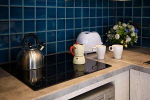 a stove top with a tea kettle and cups on a counter at Dorotea Luxury Rooms in Ipsos