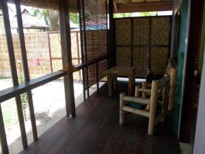 Habitación con porche con silla y mesa. en Eddie`s Beach Resort Siargao, en General Luna