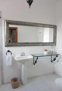 een badkamer met een wastafel en een spiegel bij Hotel Estancia de la Era B&B in Pátzcuaro