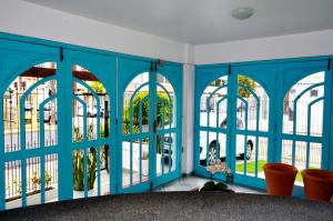 Habitación con paredes azules y ventanas grandes. en Coliseu Palace Residence, en Florianópolis
