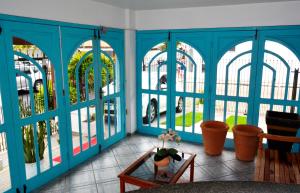 Habitación con paredes azules y ventanas con mesa. en Coliseu Palace Residence, en Florianópolis