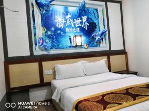 a room with two beds and a large screen at Mega Inn in Kuching