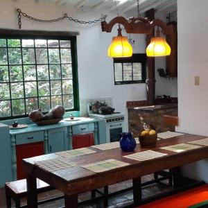 a kitchen with a wooden table in a room at Cedron Hostel in Bogotá