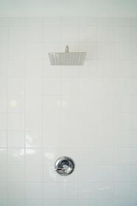 a shower with a drain in a white tiled wall at The Steady in Los Angeles