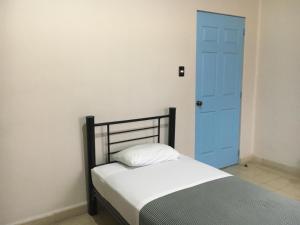 a bedroom with a white bed and blue walls at Andaina Youth Hostel in Oaxaca City