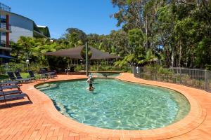 a swimming pool with a pool table and chairs at Flynns Beach Resort in Port Macquarie