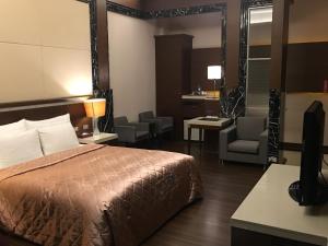 Pokój hotelowy z łóżkiem i krzesłem w obiekcie Jing Hwa Motel w mieście Tainan