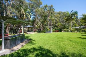 un gran patio de césped con cenador y parque en Flynns Beach Resort, en Port Macquarie