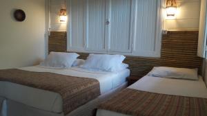 um quarto de hotel com duas camas e um armário em Flat Pico Vulcanico em Fernando de Noronha