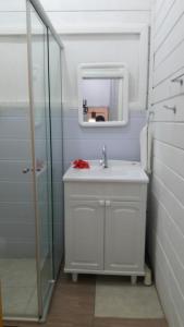 uma casa de banho com um lavatório e um espelho em Flat Pico Vulcanico em Fernando de Noronha