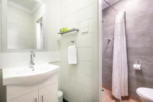 a white bathroom with a sink and a shower at Nightcap at Hendon Hotel in Adelaide