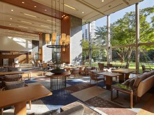 a restaurant with tables and chairs and large windows at Grand Prince Hotel Takanawa in Tokyo