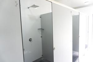 a bathroom with a glass shower with a basketball hoop at Adventure Inn Marahau in Marahau