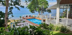 a house with a swimming pool next to the ocean at Coco Cabana Romblon in Romblon