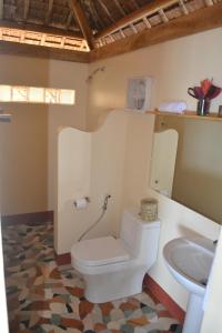 a bathroom with a toilet and a sink at Camiguin Volcan Beach Eco Retreat & Dive Resort in Mambajao