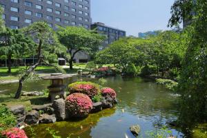 東京的住宿－高輪花香路旅館，花园,花园内设有一个种满鲜花的池塘和一个鸟浴池