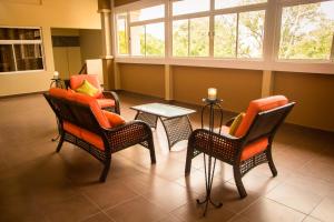 una sala d'attesa con sedie, tavolo e finestre di HM HOTEL a Choluteca