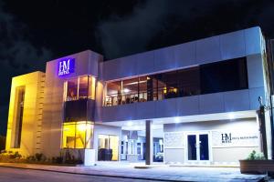 un edificio con un'insegna al neon sul lato di HM HOTEL a Choluteca