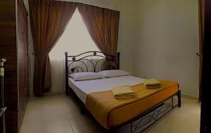 a bedroom with a large bed with a window at Melaka Homestay Tiara Golf Resort in Malacca