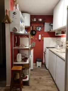 a small kitchen with red walls and white cabinets at Achiras 1432 in Montevideo