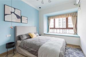 a bedroom with a bed and a window at Haikou Meilan District · Xixili Locals Apartment 00175140 in Haikou