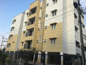 a tall building with a fence in front of it at Tulip Suites in Coimbatore