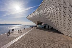 a building on the beach next to the water at Marchesa Da Bica Luxury in Lisbon