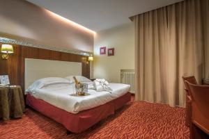 una camera d'albergo con un letto e un tavolo di Hotel Maggiore a Bologna