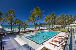 una piscina con palme e la spiaggia di Fairshore Apartment 12, Noosa Heads a Noosa Heads