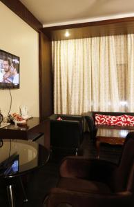 um quarto de hotel com um sofá e uma televisão em HOTEL EXCELLENCY em Bhubaneshwar