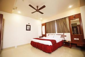 - une chambre avec un grand lit et un ventilateur de plafond dans l'établissement HOTEL EXCELLENCY, à Bhubaneswar