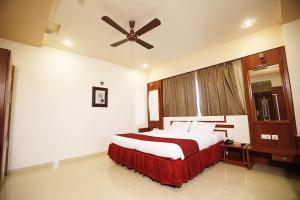 um quarto com uma cama grande e uma ventoinha de tecto em HOTEL EXCELLENCY em Bhubaneshwar
