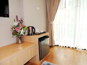 a kitchen with a vase of flowers on a counter at The U-Time Hotel in Hat Yai