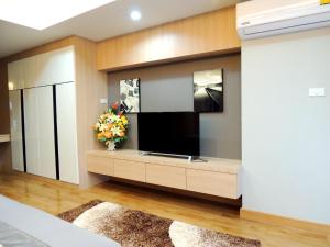 a living room with a large flat screen tv at The Raise Hotel in Hat Yai