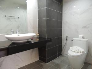 a white bathroom with a sink and a toilet at The Raise Hotel in Hat Yai