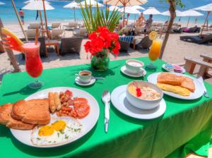 un tavolo con un piatto di prodotti per la colazione sulla spiaggia di Gili Air Bungalows a Gili Air