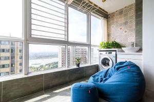 a living room with a blue couch in front of a window at Henan Luoyang·Chanhe Hui Nationality Area· Locals Apartment 00144150 in Luoyang