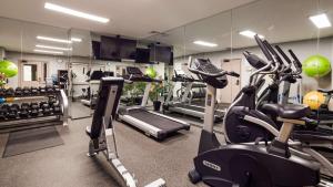 een fitnessruimte met loopbanden en crosstrainers voor een spiegel bij Best Western Fort Lee in Fort Lee