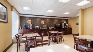 uma sala de jantar com mesas e cadeiras num restaurante em Best Western Springfield West Inn em West Springfield