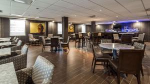 un restaurante con mesas y sillas y un bar en Best Western Premier NYC Gateway Hotel en North Bergen
