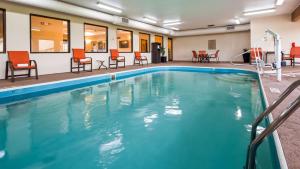 una piscina en una habitación de hotel con sillas y mesas en Best Western B R Guest, en Zanesville