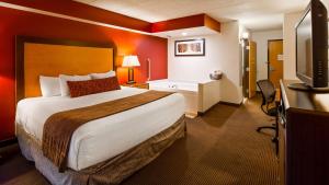 a hotel room with a bed and a desk and a television at Best Western Plus Sidney Lodge in Sidney +16 photos