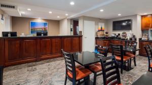 a bar with a table and chairs in a room at Best Western Fort Lee in Fort Lee